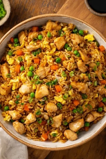 Delicious plate of restaurant-style chicken fried rice garnished with vegetables