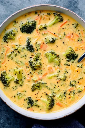 Bowl of creamy Broccoli Cheddar Soup garnished with fresh broccoli florets.