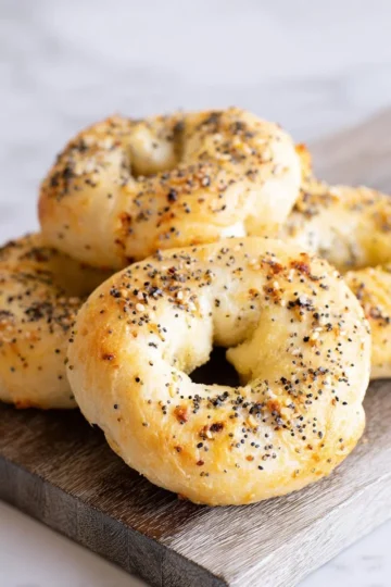 Homemade cottage cheese bagels served on a wooden table with toppings