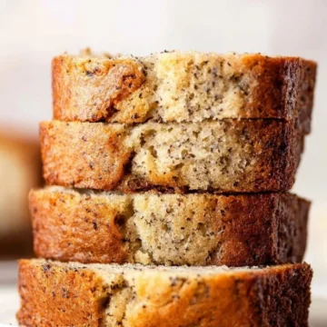 Moist banana bread slice with a golden crust and ripe bananas.