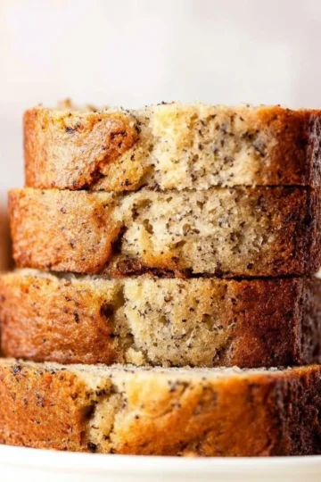 Moist banana bread slice with a golden crust and ripe bananas.