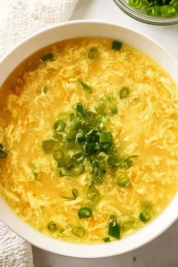 Bowl of homemade egg drop soup garnished with green onions
