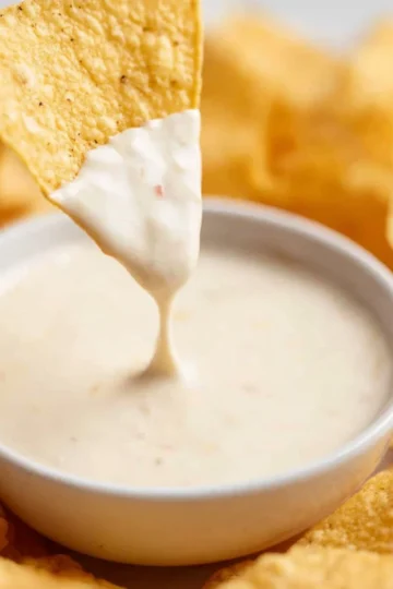 Bowl of authentic Mexican cheese dip with tortilla chips on the side