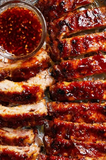 Baked Beef Ribs with BBQ sauce in a baking dish garnished with fresh herbs