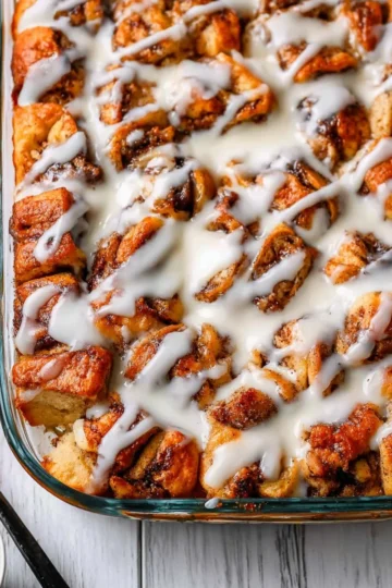 Delicious cinnamon roll casserole served with frosting on top