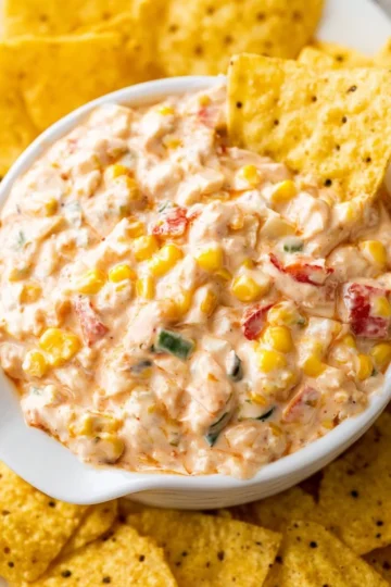 Delicious corn dip served with tortilla chips in a bowl
