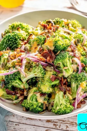 Creamy broccoli salad with dressing, nuts, and cheese in a bowl