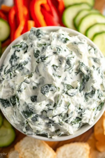Bowl of easy spinach dip served with fresh vegetables and crackers
