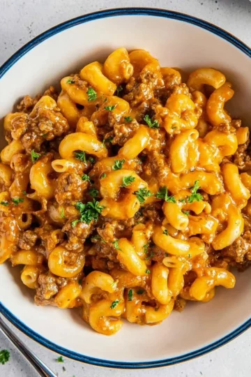 A delicious bowl of homemade Hamburger Helper topped with cheese and herbs