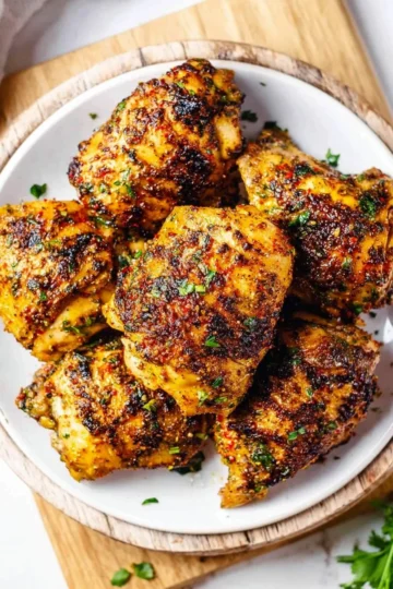 Juicy oven baked chicken thighs garnished with herbs and spices