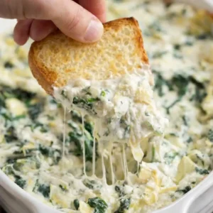 Delicious spinach artichoke dip served in a bowl with tortilla chips