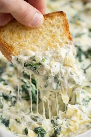 Delicious spinach artichoke dip served in a bowl with tortilla chips
