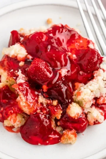 Delicious Strawberry Cheesecake Dump Cake topped with fresh strawberries.